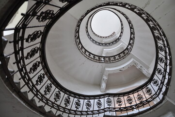 Black and white photo of old spiral staircase, spiral stairway inside old house in Rijeka, Croatia. Spiral stairs. Design spiral staircase inside an old building, circular architectural shape.
