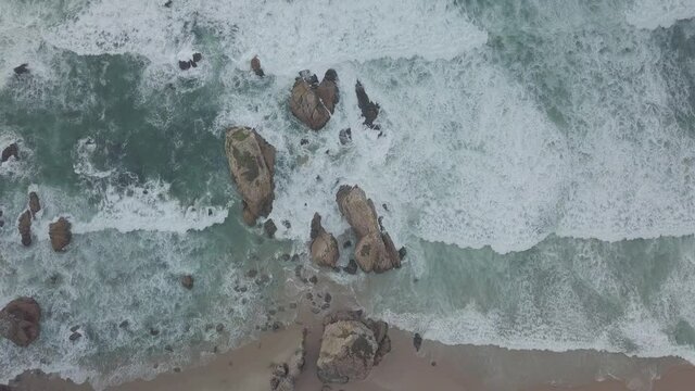 BEACH Portugal Praia da Ursa - prise de vue a&eacute;rienne de haut en bas d'une plage avec rocher dans l'oc&eacute;an Atlantique, au-dessus des vagues qui se brisent le long de la plage
