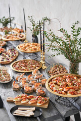 solemn banquet, table in restaurant. buffet table with lots of delicious snacks. canapes, bruschetta, and little desserts on wooden plate board