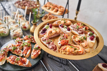 Delicious bruschetta with salmon and canape shrimp on table. Tasty buffet table. Summer party. Catering concept