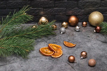 New Year and Christmas background, poster, calendar with fir branches, Christmas decorations and dried oranges on a concrete background and a brick wall. Place for your text.