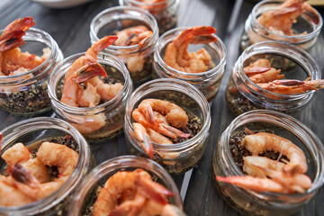 Delicious fresh seafood, shrimp with fresh vegetables. buffet table with lots of delicious snacks. canapes, bruschetta, and little desserts on wooden plate board