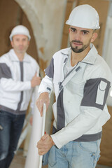 portrait of plasterer carrying a board