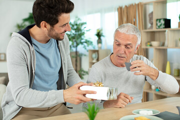 adult son congratulating senior dad with fathers day