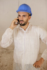 male builder wearing overalls talking on telephone
