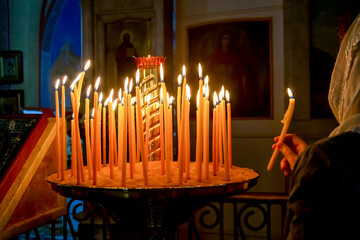 woman and candles are fired inside the Church of the Prophet Elijah in Haifa, Israel