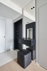 minimalistic entrance hall with a hanger mirror shelf and pouf