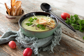 bowl of broccoli cream soup on a wooden table