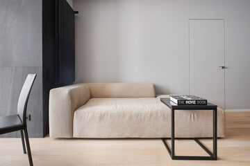 Minimalist stylish sofa in the dining area with leather chairs in the studio in monochrome colors