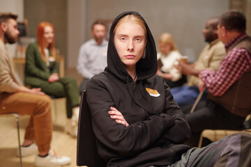 Serious girl with her arms crossed by chest attending psychological course