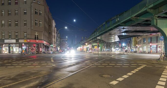 Night traffic timelapse in central Berlin, public transportation moving on a crowded city street intersection