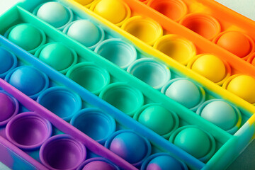 Top view of the new sensory toy - pop it,good for relieve,antistress concept.Rainbow color,concave and convex bubbles.Silicone form.
