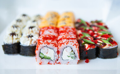 Sushi from Japanese cuisine. There are different types of sushi in the box. Delicious and healthy food delivery concept. Close-up.
