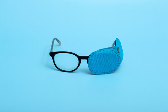 Children's glasses with occluder on a colored background. Lazy eye. Amblyopia