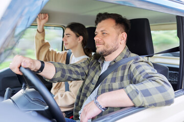 Portrait of father and teenage son together, man driving car