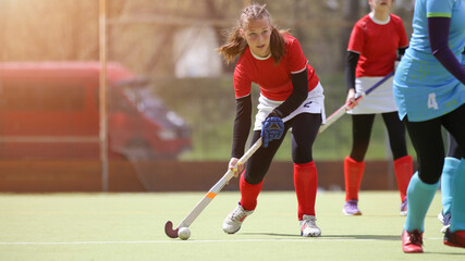 Naklejka premium Teenage field hockey player in attack with ball