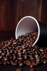 A coffee paper cup with coffee beans. Vertical image