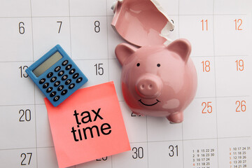 Broken piggy bank on a white calendar background, tax and savings concept