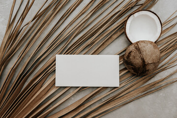 Summer stationery still life with blank paper card , fresh coconut and dry palm leaves on stone background. Minimal boho Mockup invitation. - 435504787