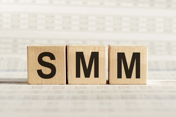 SMM abbreviation - social media marketing, on wooden cubes on a light background.