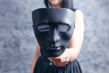 woman holding black plastic mask
