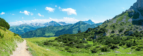 Naklejka na ściany i meble Alpine landscape. View south-easterly over the Kleinwalsertal to the Allgau Alps in the background; on the right-hand the cliffs of the mountain Hoher Ifen 