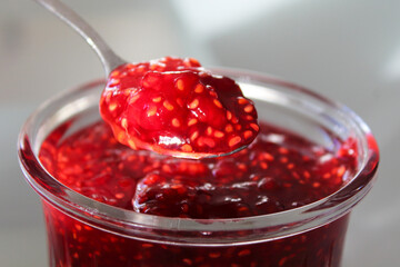 Fresh tasty jam in a glass jar. Close-up. Background.