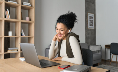 African American mixed race adult student wearing earphones having virtual meeting online call with friends, educational webinar chatting at home office. Video e learning conference call on pc.