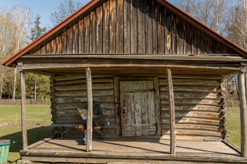 An old rural thatched-roofed farmhouse built of logs.