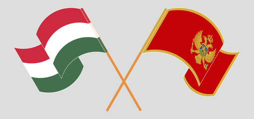 Crossed and waving flags of Hungary and Montenegro