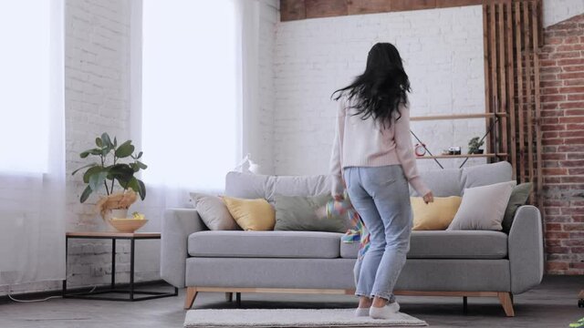 Active young mom babysiter and little kid son jumping dancing in modern house living room, happy family mother with child boy having fun enjoy playing funny activity together at home