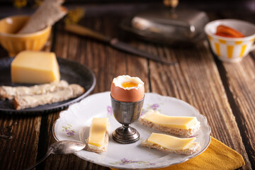 boiled egg in a silver eggcup with bread