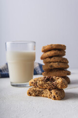 some bitten chocolate cookies with a glass of milk at the bottom