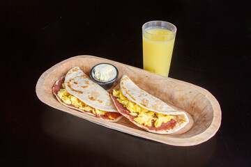 baleadas, tortillas de harina con frijoles mantequilla y huevo y jugo de naranja