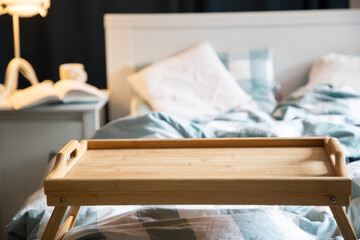 cozy bedroom detail focus on wooden breakfast tabletop