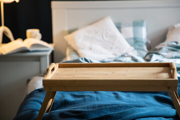 cozy bedroom detail focus on wooden breakfast tabletop