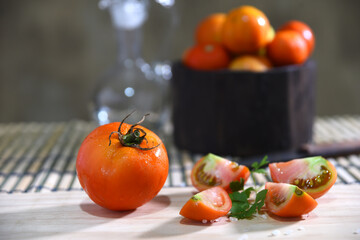 tomatoes cut into slices on the table on blurred background with space for text