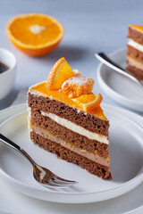 Cake, orange and coffee on a light wooden table..