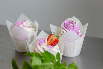 Cupcakes decorated with butter cream in white baking parchment cases