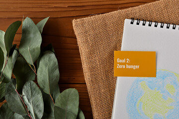 There is card with the statement Goal 2: Zero hunger
 on it one of the goals of the SDGs and a illustration of the earth.