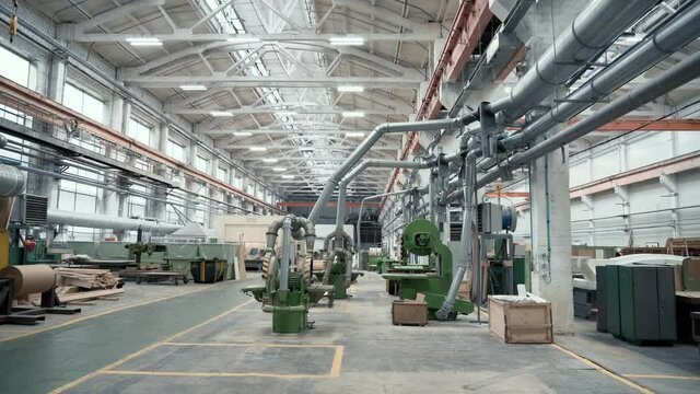 Industrial interior, factory workshop for woodworking, automatic machines, girder cranes.