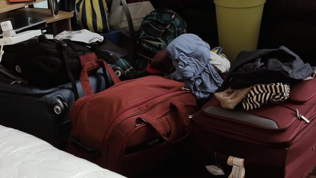 Messy Room with Various Suitcases or Travel Bags. Zoom In. 4K Resolution.