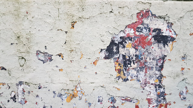 Antigua pared descascarada con varias capas de pintura da&ntilde;adas de diferentes colores