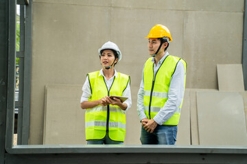 Asian female engineer explaining job on tablet to her worker on site.