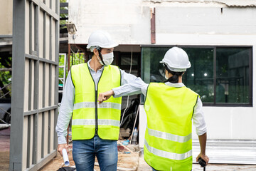 Asian architect or engineer team greeting each other by elbow bump.	