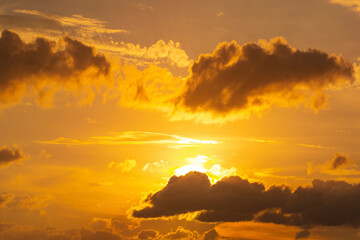 The morning sky looked like a bright golden sky. The sunrise is decorated with clouds in various shapes. Looks beautiful.