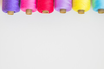 Spools of colorful threads on a white background, copy space 