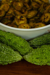 Selective focus food photography of Cooked vegetable bitter gourd and raw bitter gourd kept alongside each other 