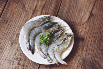 Fresh shrimp seafood for cooked food, Raw shrimps prawns on white plate - top view