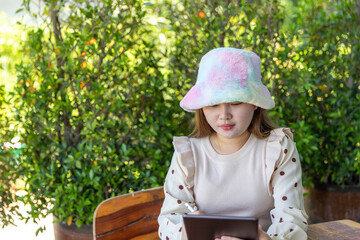 Obraz premium A girl sitting at work At the wooden table used Hand holding the touch pen to the tablet